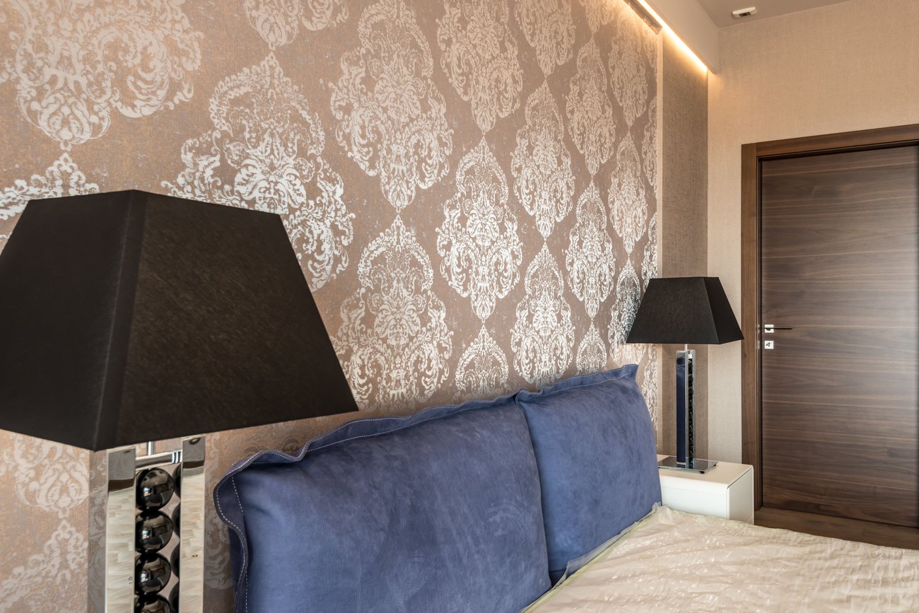 Bedroom wall finished in a metallic damask pattern wallpaper